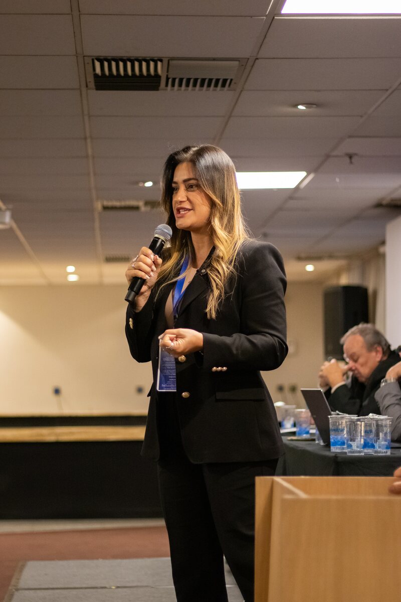 Dra. Roberta Santana ao microfone em treinamento